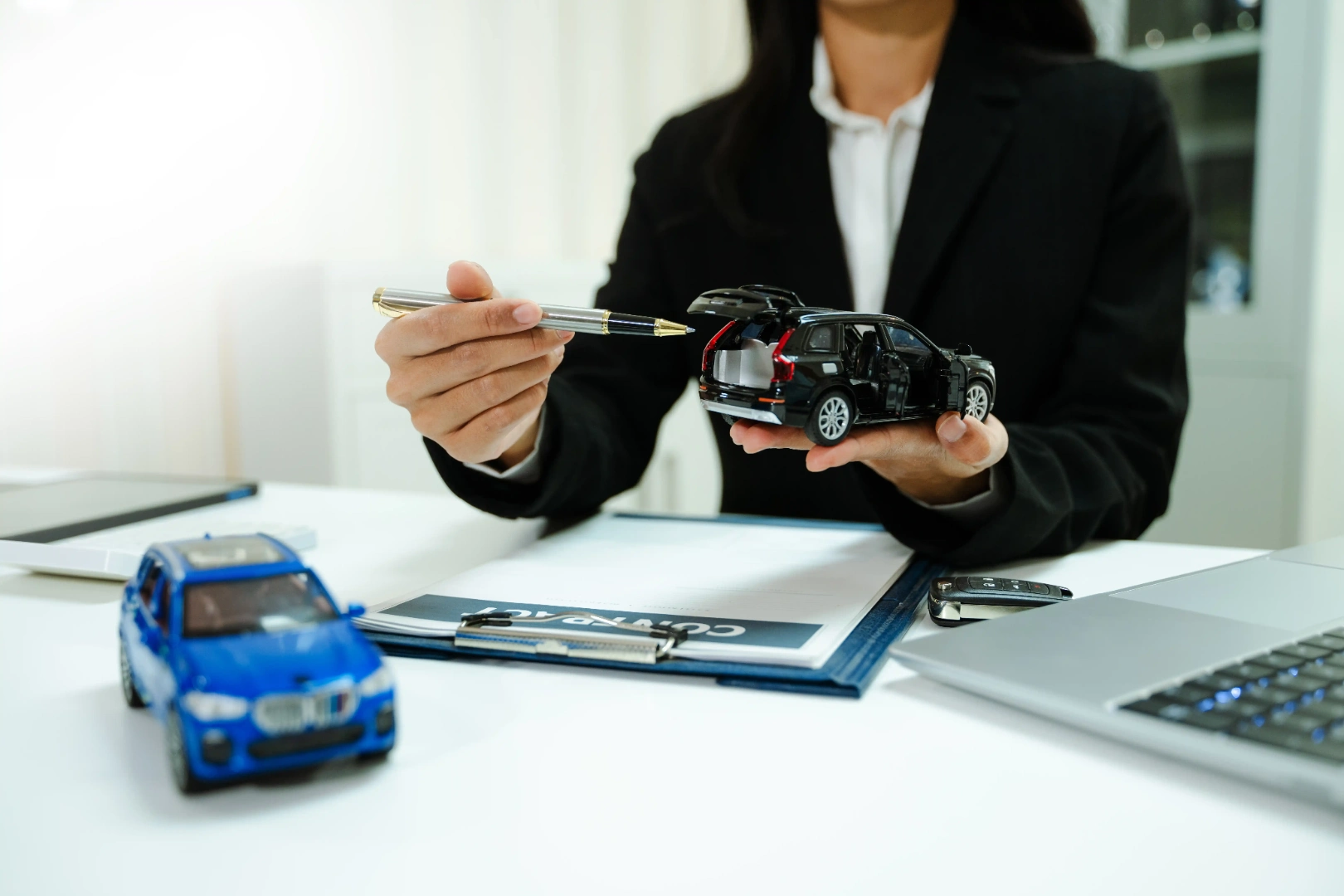 Insurance representative explaining vehicle options with model cars