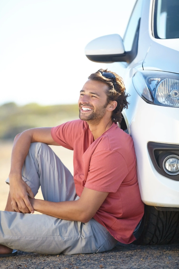 Driver sitting beside his vehicle